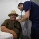 Doctor examining elderly patient with stethoscope in clinic