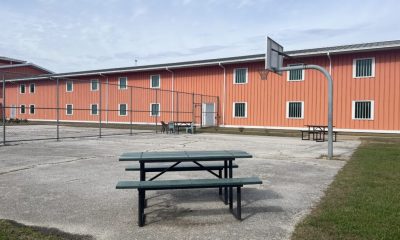 Fenced yard with basketball hoop and picnic tables