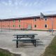 Fenced yard with basketball hoop and picnic tables