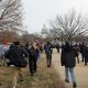 Crowd walking toward U.S. Capitol in winter.