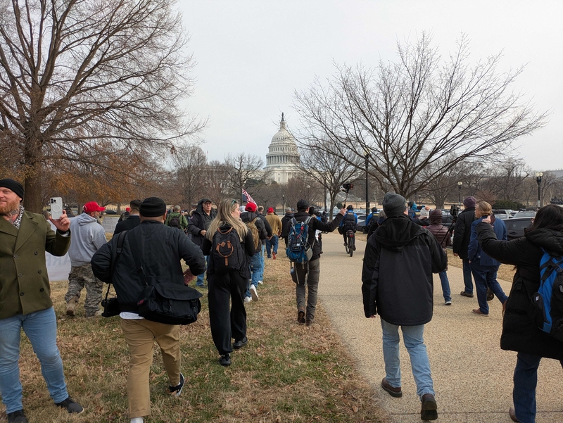 Crowd walking toward U.S. Capitol in winter.
