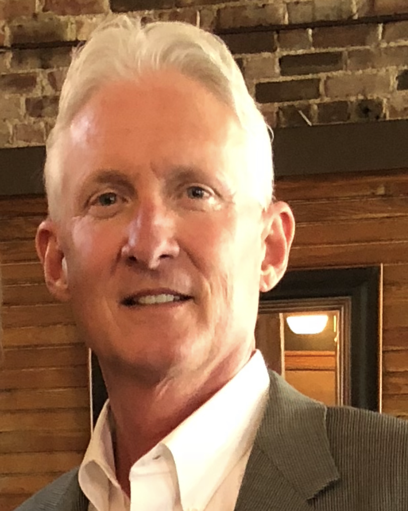Portrait of gray-haired man in blazer indoors