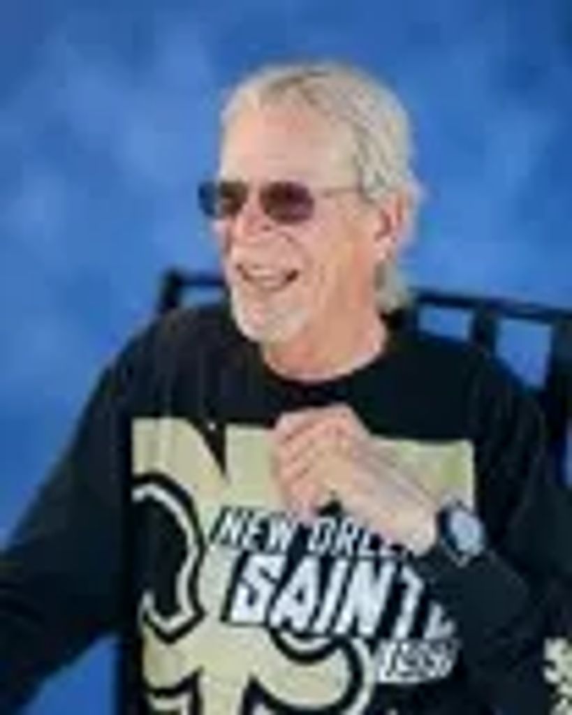 Smiling man wearing New Orleans Saints shirt