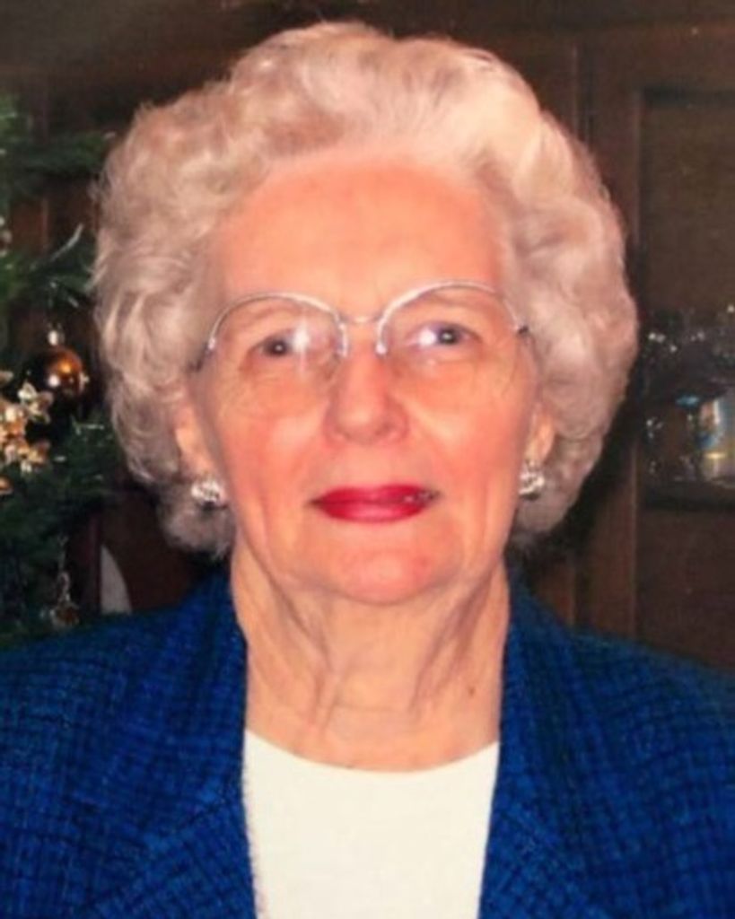Elderly woman with white hair and glasses smiling