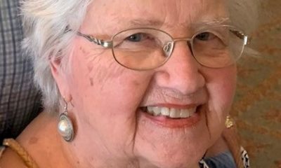 Smiling elderly woman wearing glasses and earrings