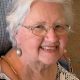 Smiling elderly woman wearing glasses and earrings
