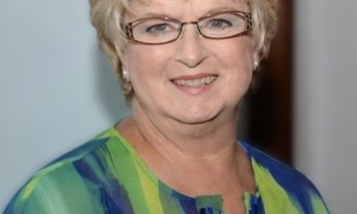 Smiling woman with glasses in green blouse
