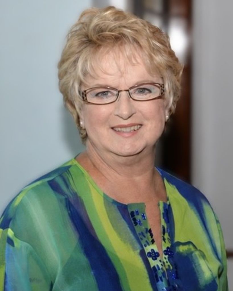 Smiling older woman with glasses and short blonde hair