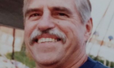 Smiling gray-haired man with mustache outdoors