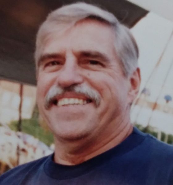Smiling gray-haired man with mustache outdoors