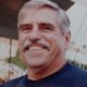 Smiling gray-haired man with mustache outdoors