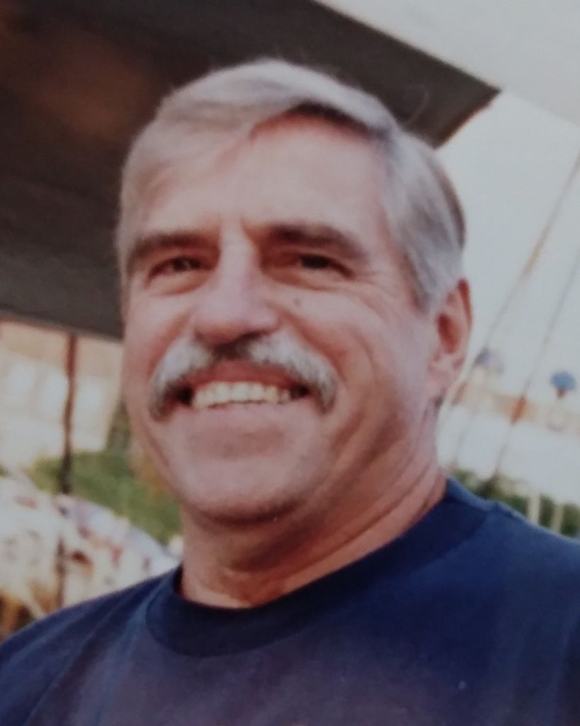 Smiling gray-haired man with mustache outdoors