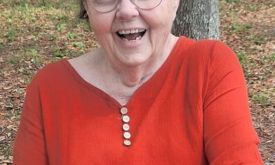 Smiling elderly woman in red shirt outdoors