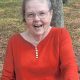 Smiling elderly woman in red shirt outdoors