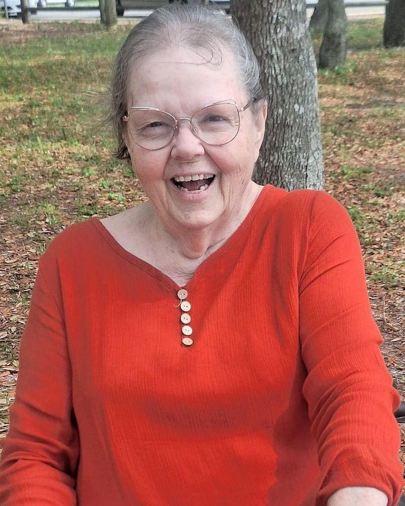 Smiling elderly woman in red shirt outdoors