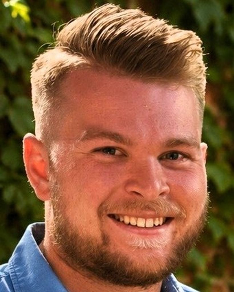 Smiling young man with blond hair outdoors