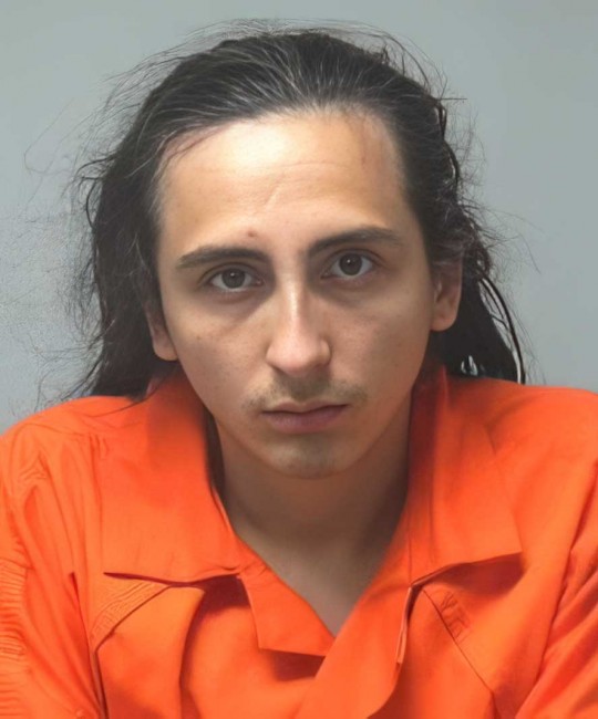 Person in orange shirt against plain background