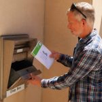 Man placing envelope into secure drop box — Florida mail-in voting Supreme Court ruling — voto por correo Florida