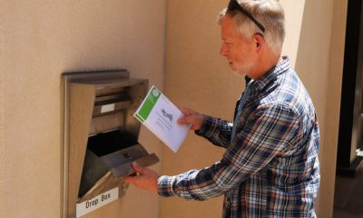 Man placing envelope into secure drop box