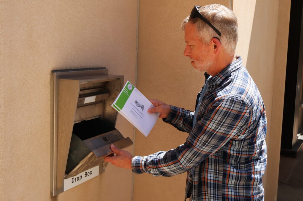 Man placing envelope into secure drop box