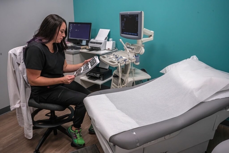 Healthcare professional reviewing ultrasound images in exam room