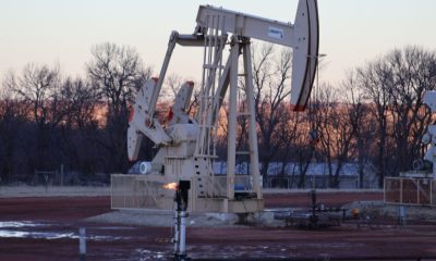 Oil pumpjack operating at dusk in rural field
