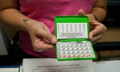 Person holding open birth control pill pack