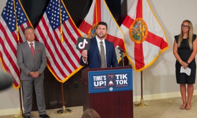Man holds TikTok logo at press conference podium