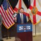 Man holds TikTok logo at press conference podium
