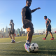 Man controlling soccer ball on city field