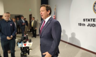 Official speaking at press conference with microphones