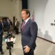 Official speaking at press conference with microphones