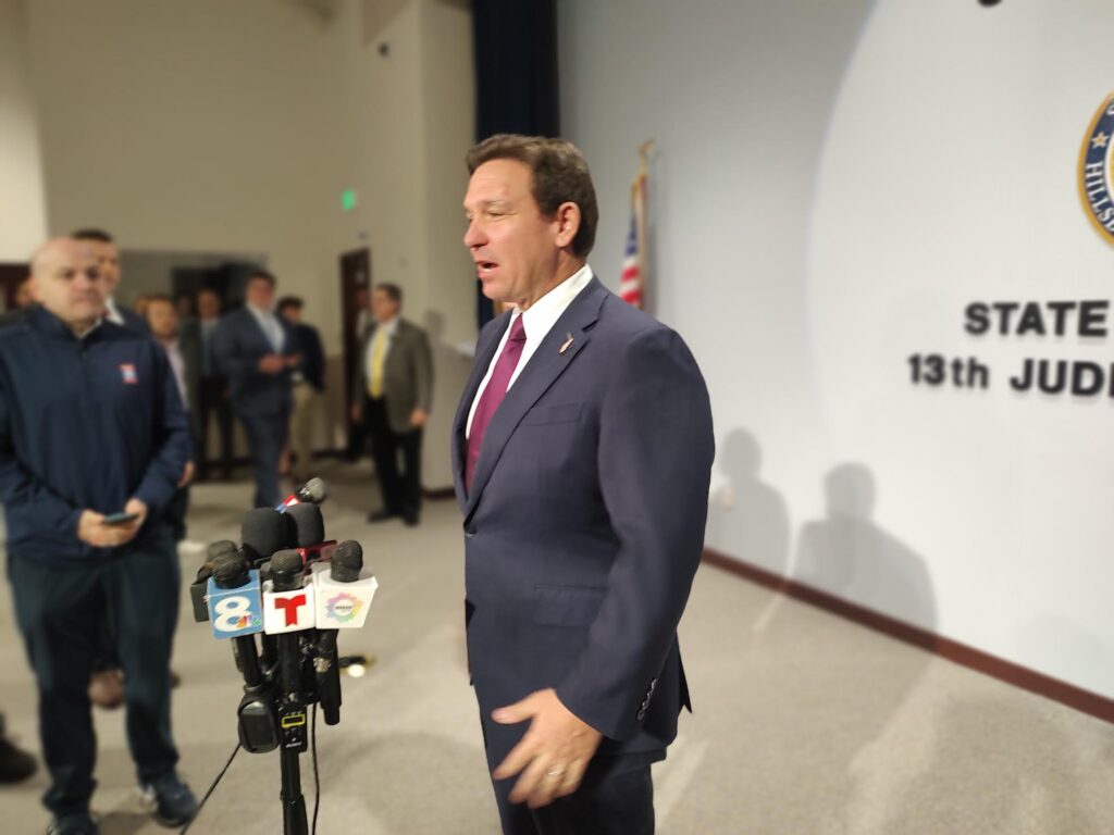 Official speaking at press conference with microphones