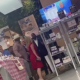 People posing inside a retail store with product shelves