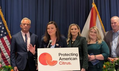 Officials at podium promoting American citrus protection