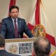 Man speaking at Florida press conference podium