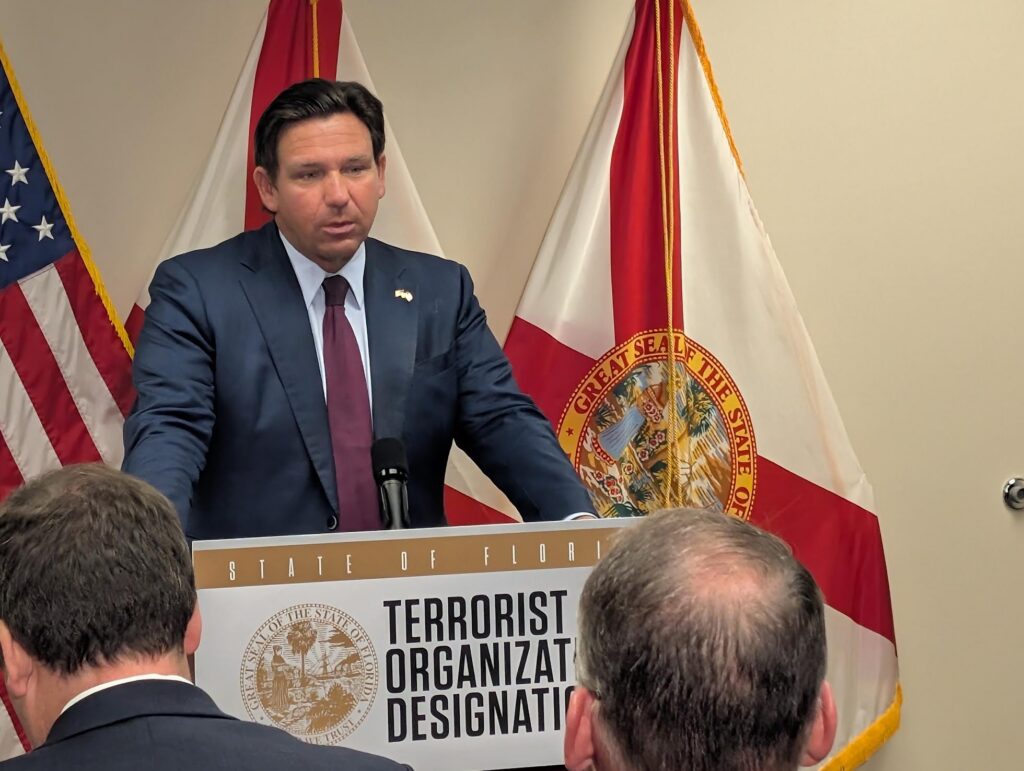 Man speaking at Florida press conference podium