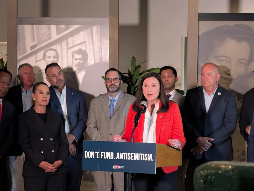 Woman speaking at podium about antisemitism