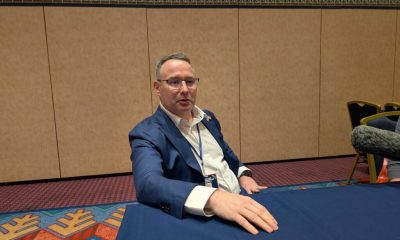 Man in blue suit seated at conference table