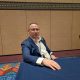 Man in blue suit seated at conference table