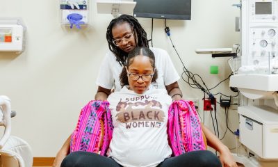 Pregnant woman supported in medical exam room