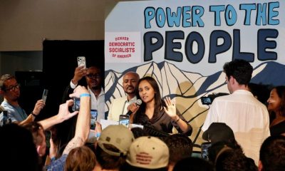 Woman speaking at political rally with crowd