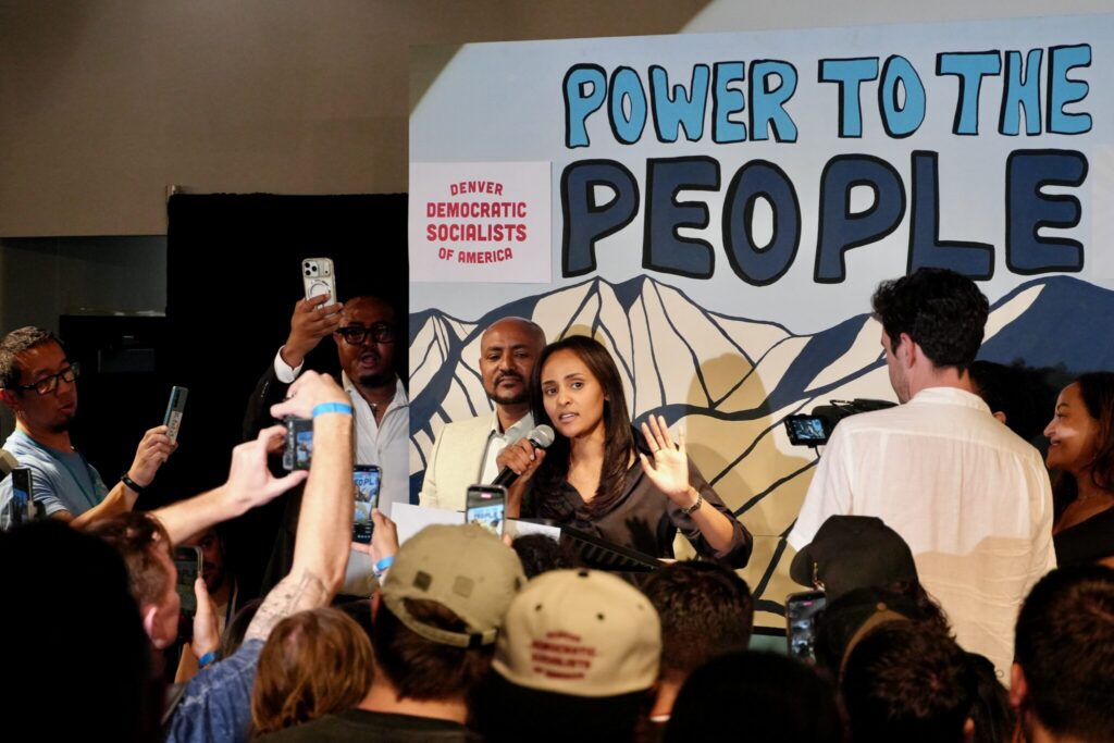 Woman speaking at political rally with crowd