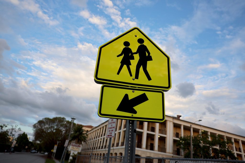 Yellow school crossing sign with left arrow