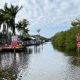 Narrow canal with palm trees and no wake signs