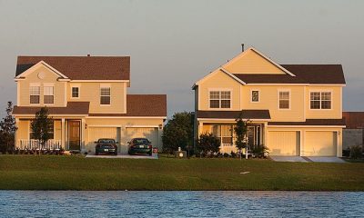 Two suburban houses by lakeside at sunset