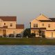 Two suburban houses by lakeside at sunset