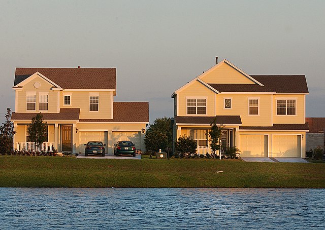 Two suburban houses by lakeside at sunset