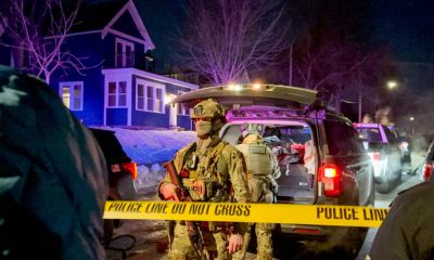 Armed police officers behind yellow crime scene tape