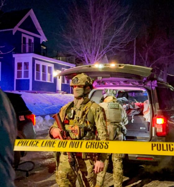 Armed police officers behind yellow crime scene tape